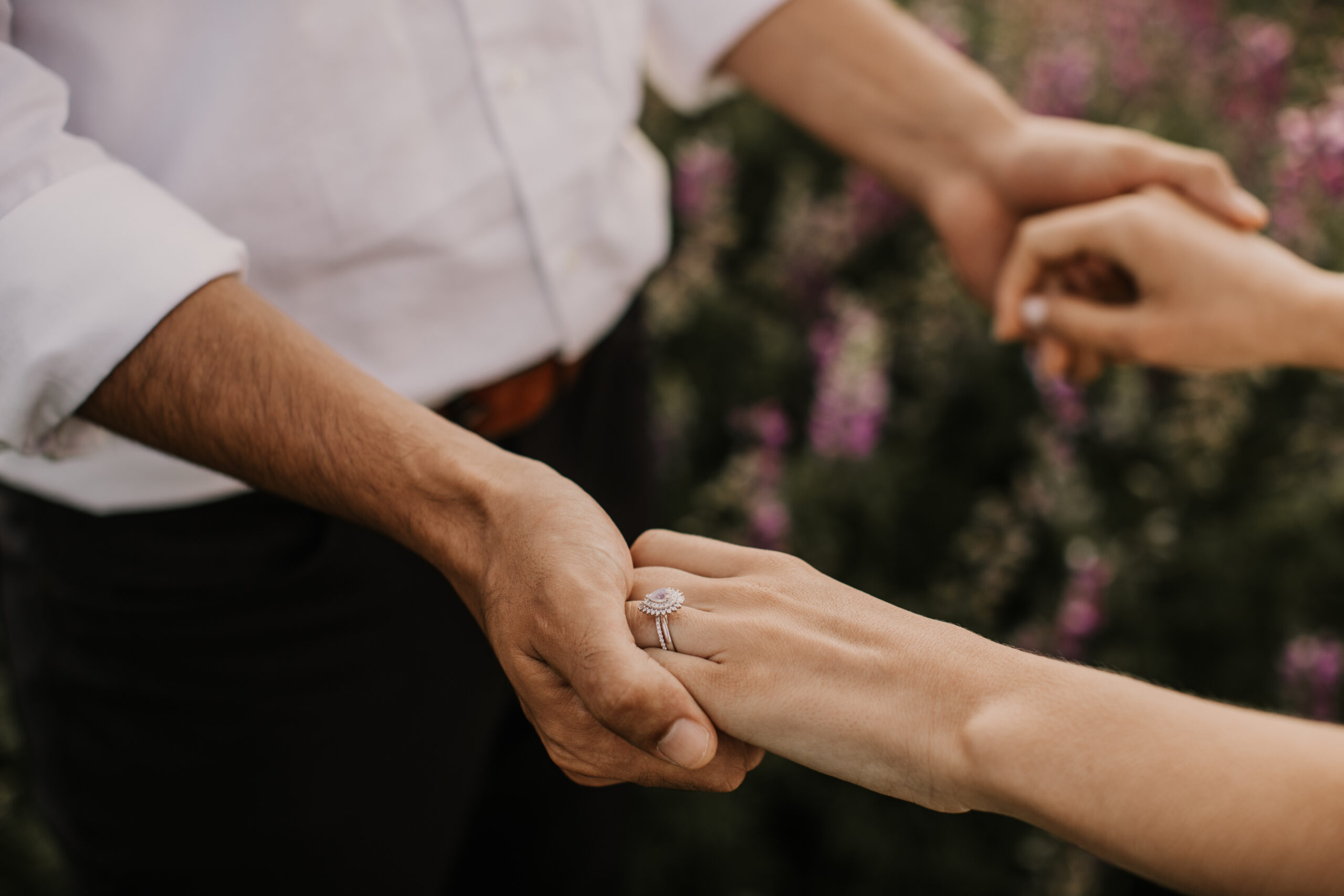 Holding hands in a patch of purple lupine flowers